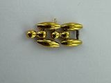 a close up of a gold plated object on a white surface