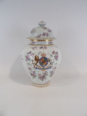 un petit vase avec un couvercle posé sur une table blanche
