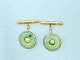 a pair of green and gold earrings on a blue background