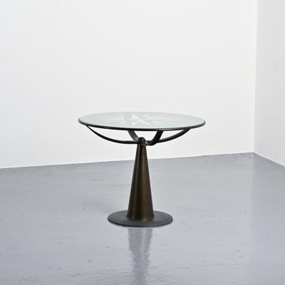 une table en verre avec un piètement en métal dans une pièce blanche