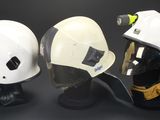 three helmets on display on a black background