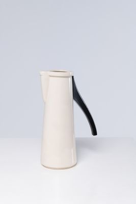 une cafetière blanche et noire posée sur une table blanche