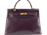 un sac à main en cuir violet avec des finitions dorées sur la poignée