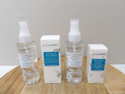 trois flacons de soins pour la peau posés sur une table en bois