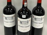 three bottles of red wine are lined up on a white surface