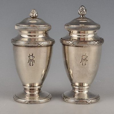 pair of silver vases with chinese writing on them on a table