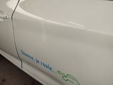 a white car with a green sticker on the side of it
