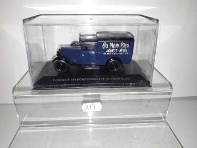 a blue truck in a clear display case on a table
