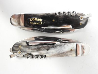 pair of knives with a corkscrew inside of them on a white surface
