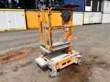 an image of a scissor sitting on the ground in front of shipping containers