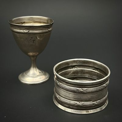 une coupe en argent posée à côté d'une autre coupe en argent sur une table