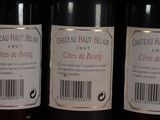 three bottles of red wine are lined up on a shelf