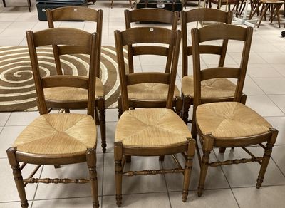 Plusieurs chaises sont disposées en cercle sur un sol carrelé.