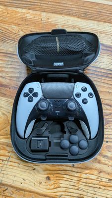 une manette de jeu vidéo noire et blanche dans un étui noir