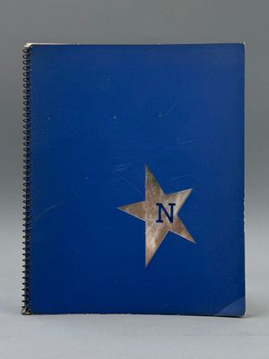 un cahier bleu sur lequel figurent la lettre « n » et une étoile sur la couverture