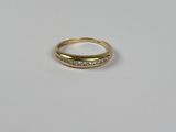 gros plan d'une bague en or avec des diamants sur une surface blanche