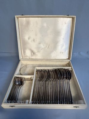 silverware in a silver case on a blue surface