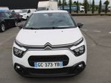 une Citroën blanche garée sur un parking