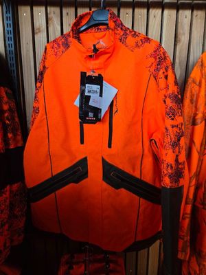an orange jacket hanging on a rack in a clothing store