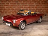a red sports car parked in front of a brick wall