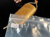 a bag with a gold object inside of it on a table