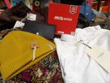 a pile of clothing and a box on top of a bed