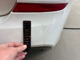a hand that is holding a ruler next to a car