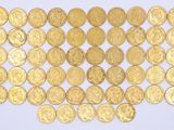a lot of gold coins on a white surface
