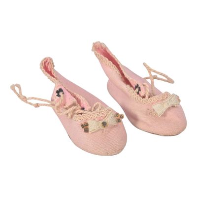 une paire de chaussons roses ornés de nœuds et de lacets
