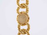 a close up of a gold bracelet with a coin on it