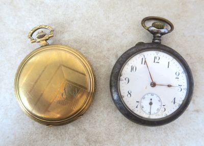 deux vieilles montres de poche posées l'une à côté de l'autre sur une table