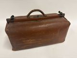 valise en cuir marron sur fond blanc, avec une poignée et une autre poignée