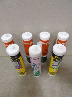 six tubes of glue are lined up in a row on a table