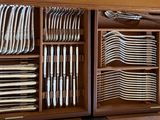 a lot of plates and spoons in a wooden box