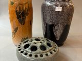 three vases sitting on a table with labels on them