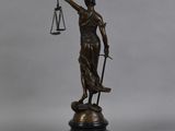 a bronze statue of a lady justice holding a sword and scales