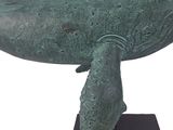 bronze sculpture of a humpback whale on a black base