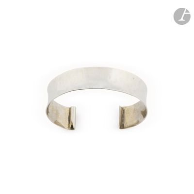 un gros plan d'un bracelet manchette en argent sur fond blanc