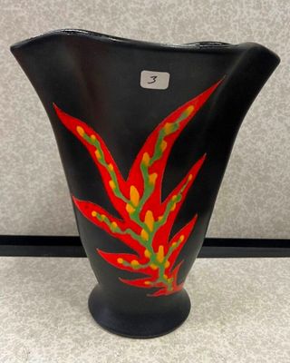 un vase noir orné d'un motif rouge et vert