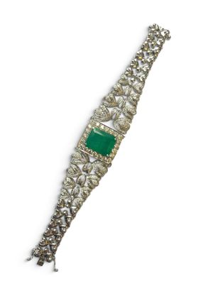 un gros plan d'un bracelet orné d'une pierre verte