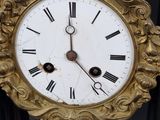 a gold clock with roman numerals on the face