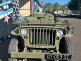une jeep militaire garée devant un immeuble