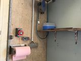 une salle de bains équipée de toilettes et d'une étagère sur laquelle est posé un rouleau de papier toilette