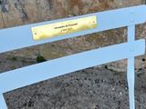 a white bench that has a plaque on it