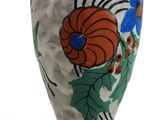 a vase with a flower design on it on a white surface