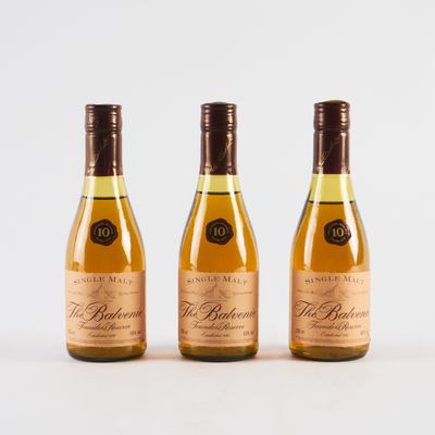 trois bouteilles de vin posées les unes à côté des autres sur une surface blanche