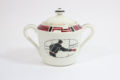 une tasse avec un couvercle sur lequel est représenté un joueur de hockey