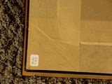 a brown box with a white sticker on it sitting on a carpet