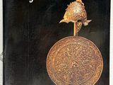 la couverture du livre « Antiquités et objets d'art », sur laquelle figure un oiseau posé sur une pièce de monnaie