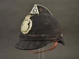 an old helmet with a badge on it sitting on a stand